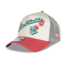 Load image into Gallery viewer, A New Era trucker hat featuring a cream-colored front panel with 'El Diabla' embroidered in teal script, a teal wave sign, and red roses, paired with a red visor and gray mesh back.