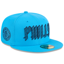 Load image into Gallery viewer, A bright blue fitted baseball cap with 'PHILLY' embroidered in a stylized black font across the front, a circular 'DC' patch on the side, and a New Era 50FIFTY sticker on the visor, shown on a white background.